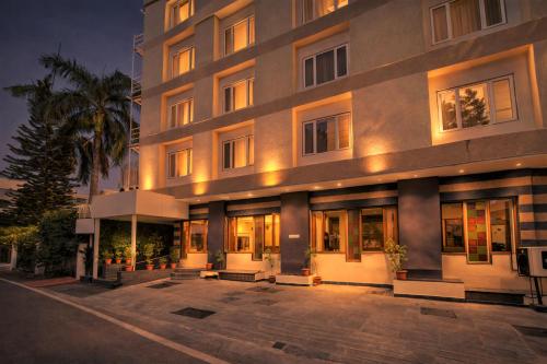 a large building with a parking lot in front of it at Hotel Mandovin - A Premium Hotel In Udaipur in Udaipur