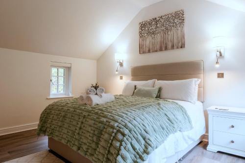 a bedroom with a large bed with two stuffed animals on it at Finest Retreats - Alpine Cottage in Symonds Yat