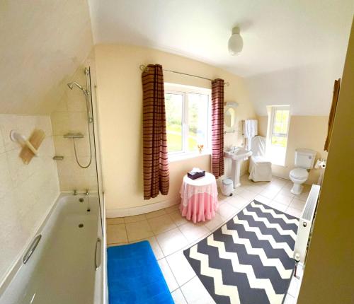 a bathroom with a tub and a shower and a toilet at Muxnaw Lodge in Kenmare