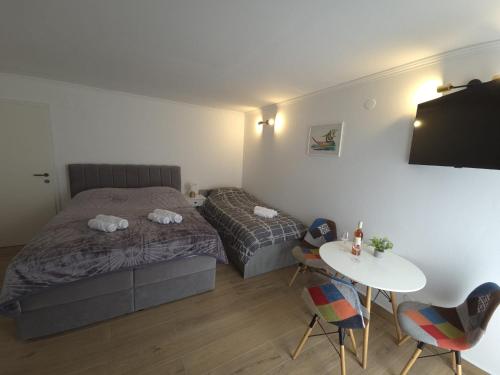 a bedroom with a bed and a table and chairs at Guesthouse Ivan in Skradin