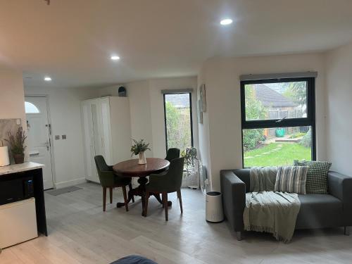 a living room with a table and a couch at Wisteria en-suite guest room in Hillingdon