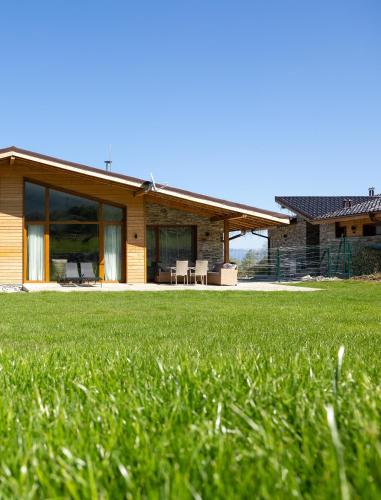 a house with a green lawn in front of it at Villa Eliyas near the Pirin Golf Resort in Razlog