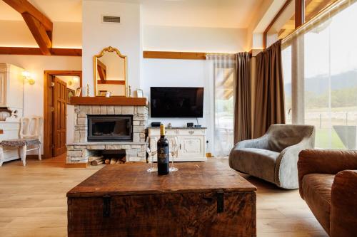 a living room with a bottle of wine on a table at Villa Eliyas near the Pirin Golf Resort in Razlog