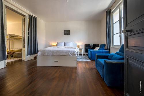 a bedroom with a bed and a blue couch at Maison au cœur de Saumur Cour privée Parking gratuit Wi-Fi in Saumur