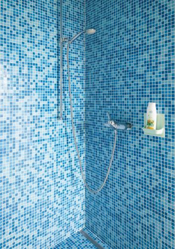 a bathroom with a shower with blue tiles at B&B Château de Denens in Denens