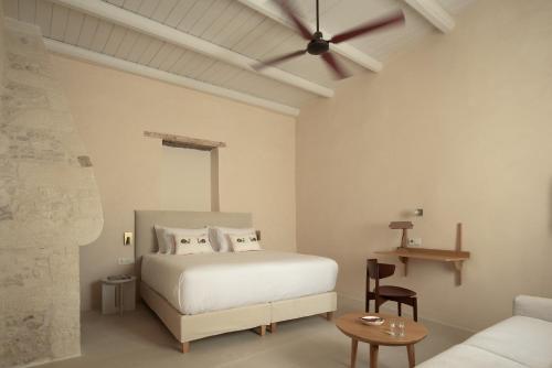 a bedroom with a white bed and a couch at Moshoviti Residence in Rethymno