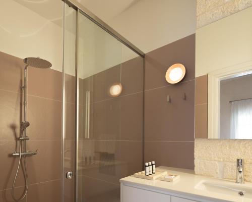 a bathroom with a glass shower and a sink at Moshoviti Residence in Rethymno