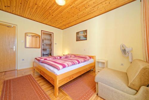 a bedroom with a bed and a couch and a chair at Rooms Milica in Palit