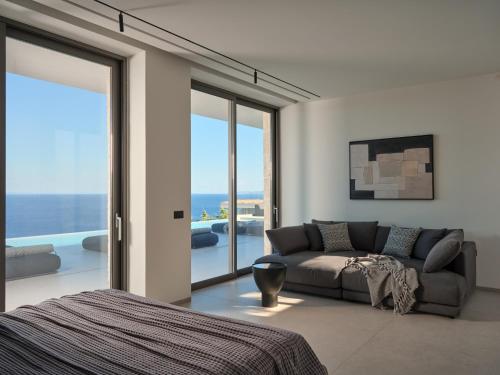 a living room with a couch and a view of the ocean at On The Rocks 7 Bedroom Villa in Koríthion