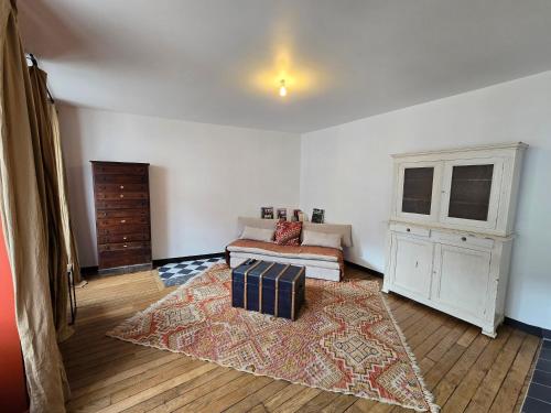 a living room with a couch and a rug at La Grande Glycine in Coulommiers