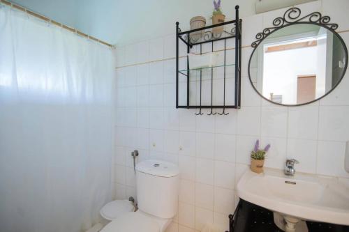 a bathroom with a toilet and a sink and a mirror at Villa Maistro Cottage by Villa Plus in Ágios Stéfanos