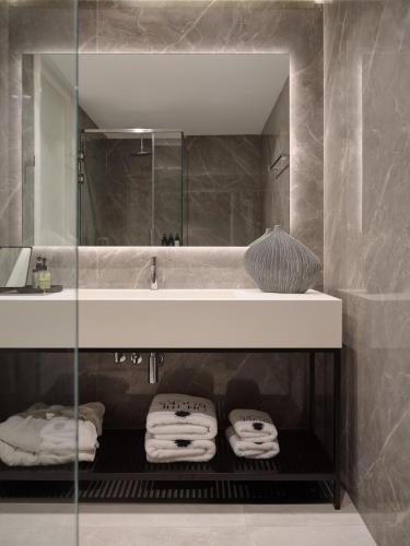 a bathroom with a sink and a mirror and towels at On The Rocks 7 Bedroom Villa in Koríthion