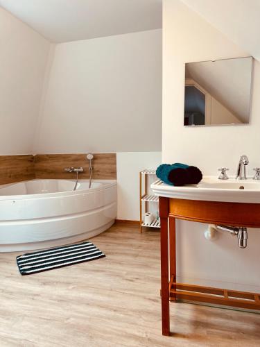 ein Badezimmer mit Badewanne und Waschbecken in der Unterkunft Unieke vakantiewoning met jacuzzi in de natuur in Het Laar
