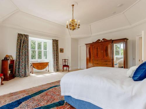a bedroom with a large bed and a chandelier at 7 Bed in Dollar oc-88668 in Powmill