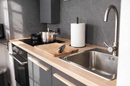 a kitchen counter with a sink and a stove at Deluxe Urban Stay in Linz