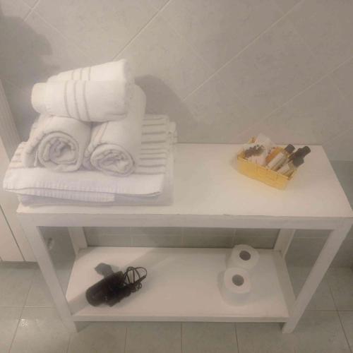 a white shelf with towels and a roll of toilet paper at Agriturismo Cascina Binelli in Dogliani