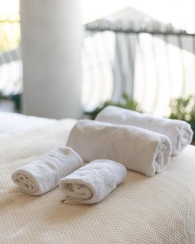 three towels sitting on top of a bed at Villa Florence in Tirana