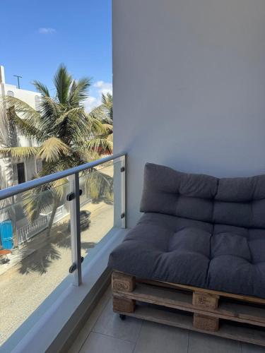 a couch sitting on a balcony with a palm tree at Casa El Mundo in Sal Rei