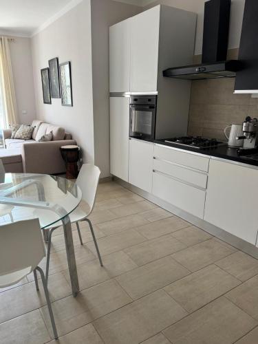 a kitchen with white cabinets and a glass table at Casa El Mundo in Sal Rei