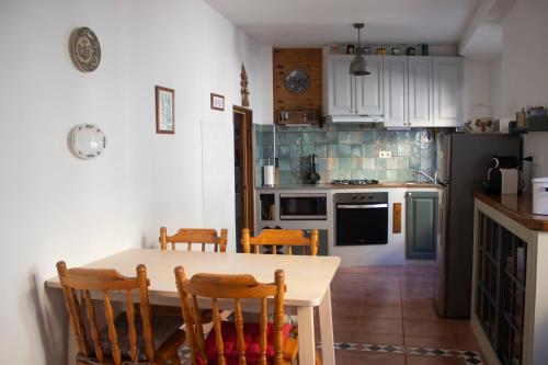 a kitchen with a table and chairs in a kitchen at Casa 7 in Sintra