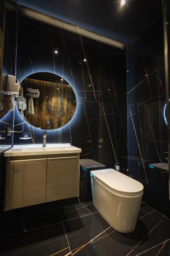 a bathroom with a toilet and a sink and a mirror at LakeSide Hotel by EDEN Group in Tashkent