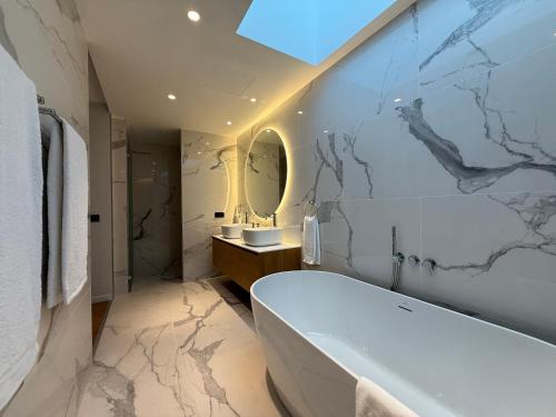 a bathroom with a white tub and a sink at Tembo Barcelona in Barcelona