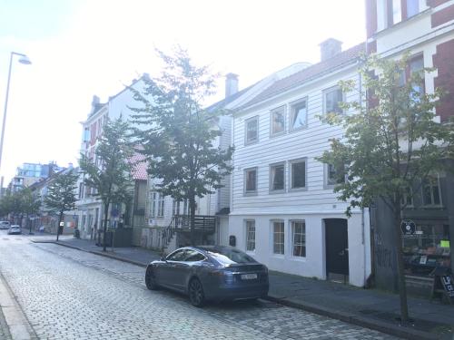 a car parked on the side of a cobblestone street at Bergen City Apartment Nygårdsgaten in Bergen