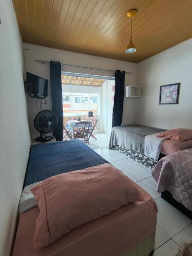 a bedroom with two beds and a view of a patio at Mandalas Guest House in Cabo Frio