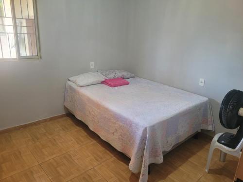 a bedroom with a bed with a table and a chair at Casa Correntina BA 3 quartos in Correntina