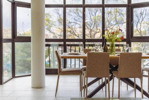 a dining room with a table and chairs and windows at Spacious 3BR Retreat Overlooking Marina in Msida