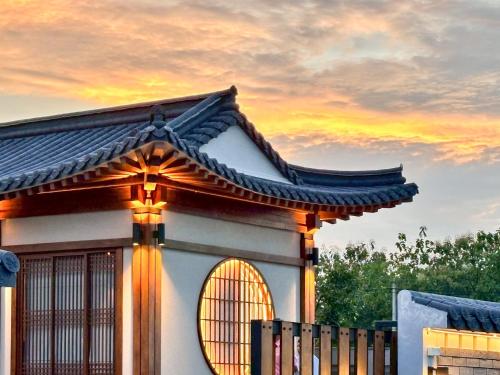 a building with a window and a sunset in the background at Krajokkaew Inyeon Khao Yai in Ban Khlong Yang