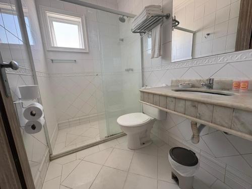 ein Badezimmer mit Toilette, Dusche und Waschbecken in der Unterkunft Jequitiba Hotel Frente ao Mar in Guarujá