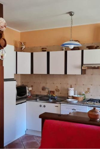 a kitchen with white cabinets and a sink at Respiro di montagna by Lago Maggiore Rentals in Vigino