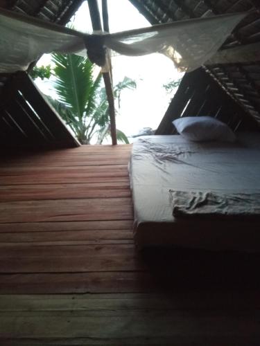 a bedroom with a bed and a wooden floor at Maison typique Madagascar in Anjiabe