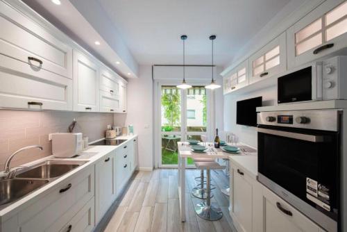 a kitchen with white cabinets and a table in it at Bed&Dreams con Jacuzzi in Bergamo