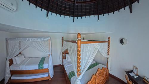 a bedroom with two beds and a ceiling at Villa Manureva in Canggu