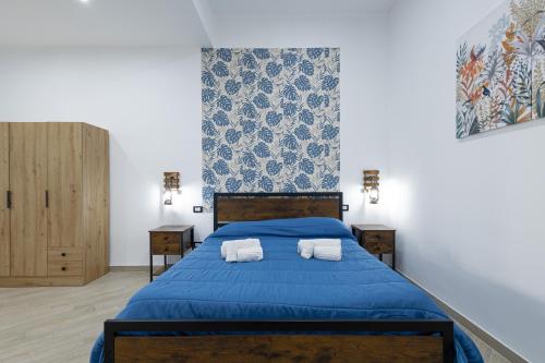 a bedroom with a blue bed and two night stands at Scorcio di Mare By Dimora Hub in Balestrate