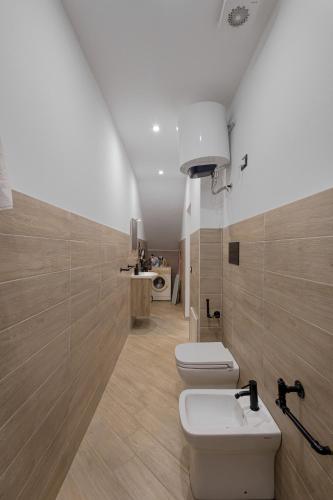 a bathroom with two toilets and a sink at Scorcio di Mare By Dimora Hub in Balestrate