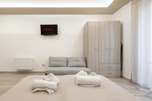 a living room with a bed and a couch at Terrasini Center Apartments By Dimora Hub in Terrasini