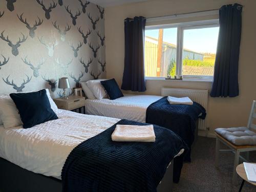 a hotel room with two beds and a window at The Island View B&B - A1 in Berwick-Upon-Tweed