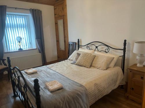 a bedroom with a bed with two towels on it at Rose Cottage in Greencastle