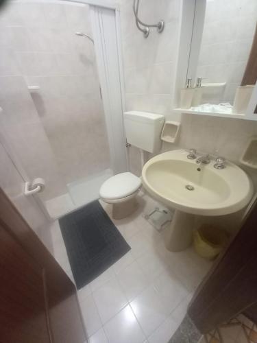 a white bathroom with a toilet and a sink at Casa Maria Naxos in Giardini Naxos