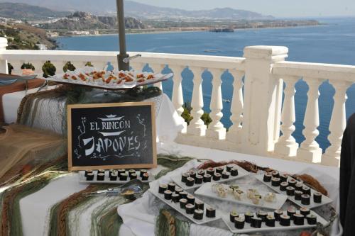 a table with food on top of a balcony at Hotel Salobreña Suites in Salobreña