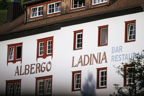 a building with the sign for the bar labrador restaurant at Berghotel Ladinia in Corvara in Badia