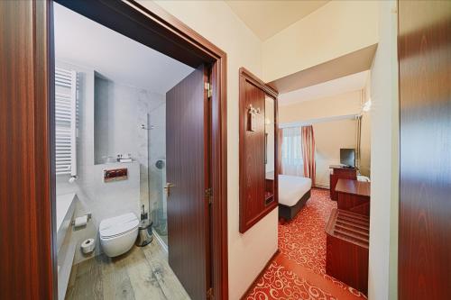a bathroom with a toilet and a sink at Hotel Central in Ploieşti