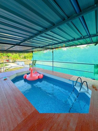 a swimming pool with a red float in a building at สมหวัง โฮมสเตย์ in Ban Khuan Suan