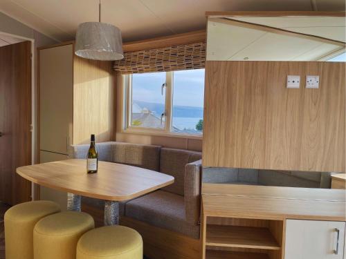 a dining room with a table and a bottle of wine at Hendre Coed Isaf Caravan Park in Barmouth