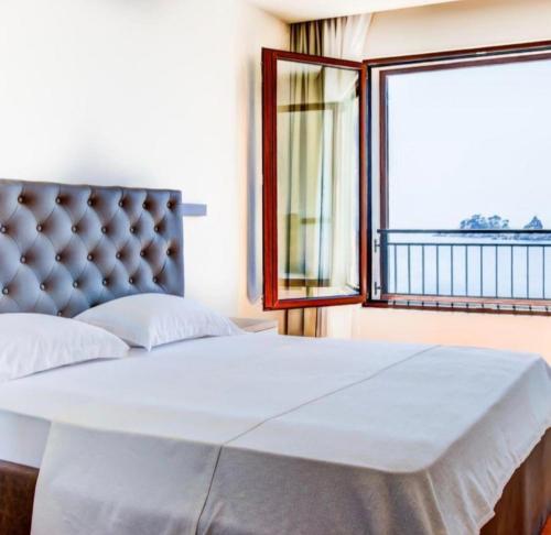 a bedroom with a large bed and a window at Mar de Lux in Petrovac na Moru