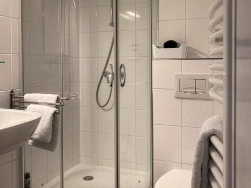 a bathroom with a glass shower with a sink at Bed & Breakfast Bep - Klein aber fein in Naumburg