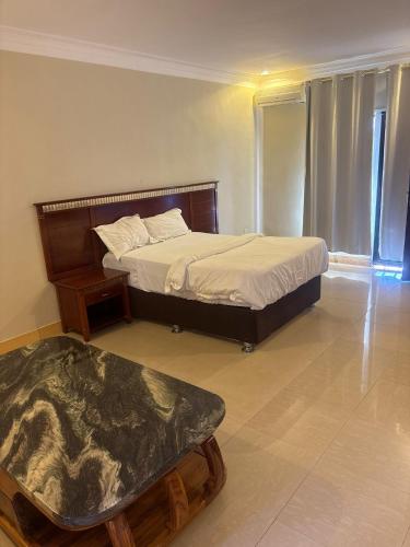 a bedroom with a bed and a table in it at Sefitel in Lubumbashi